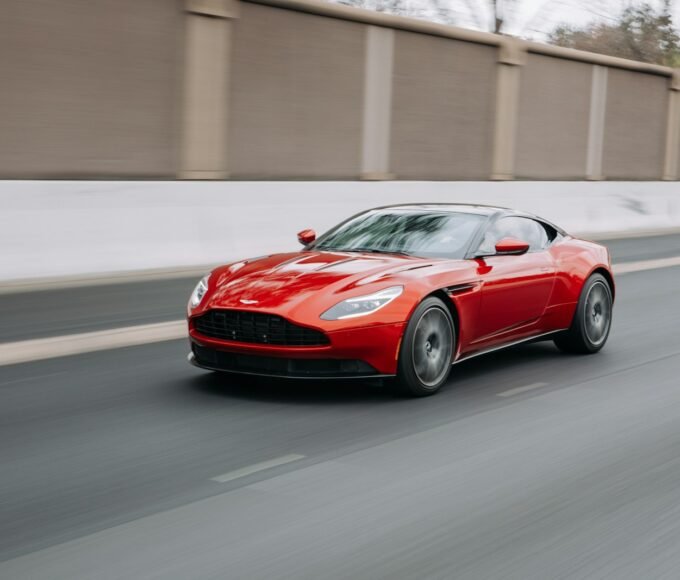 red coupe passing on road