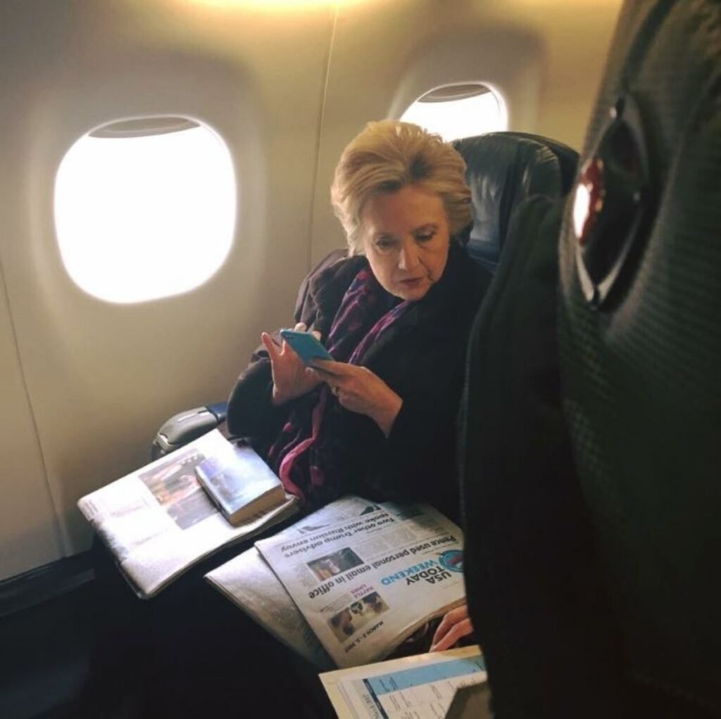 A picture of Hilary Clinton sitting in coach.