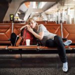 A picture of a woman sleeping in the airport and hungry