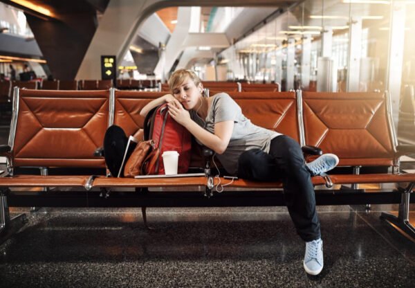 A picture of a woman sleeping in the airport and hungry