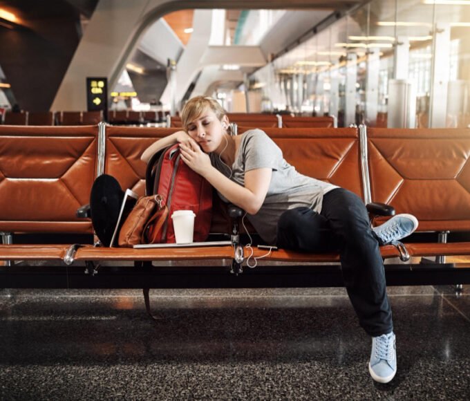 A picture of a woman sleeping in the airport and hungry